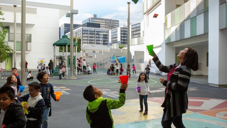 Kids and and adult playing outside.