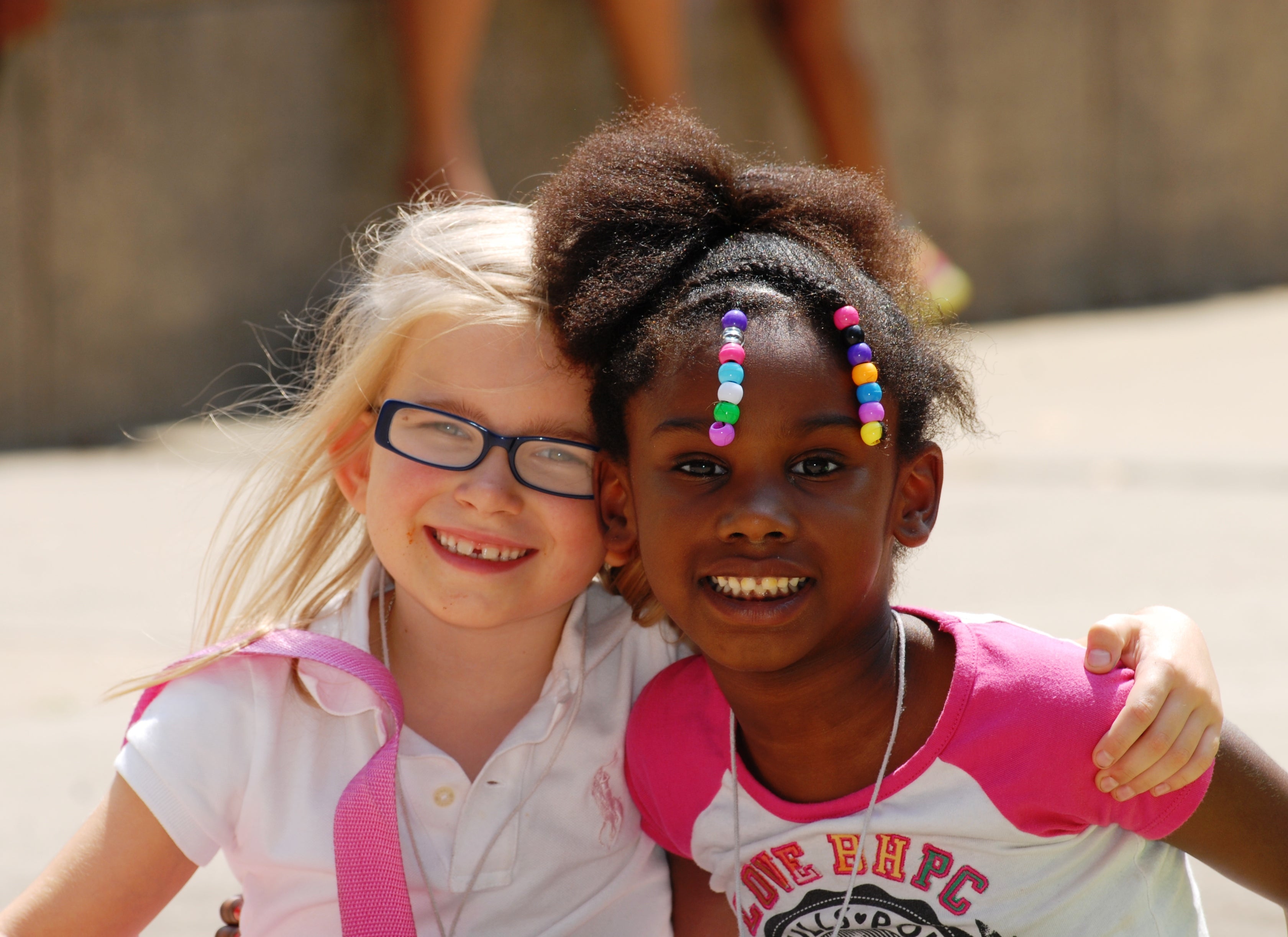 Two young girls smile at the camera.