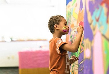 A young man draws on the wall