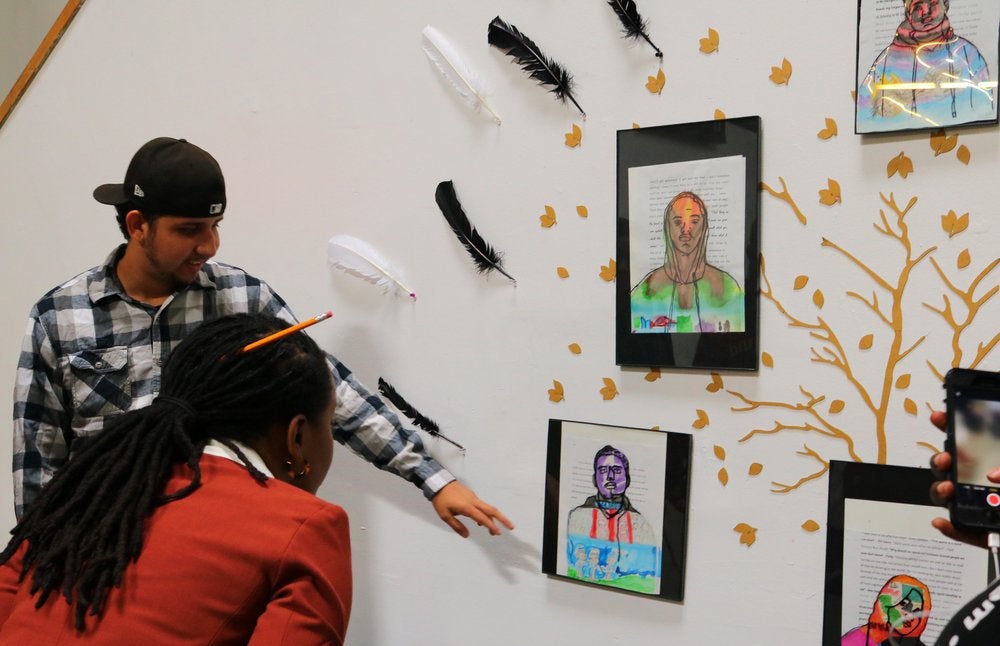 Male and female students pointing at drawings